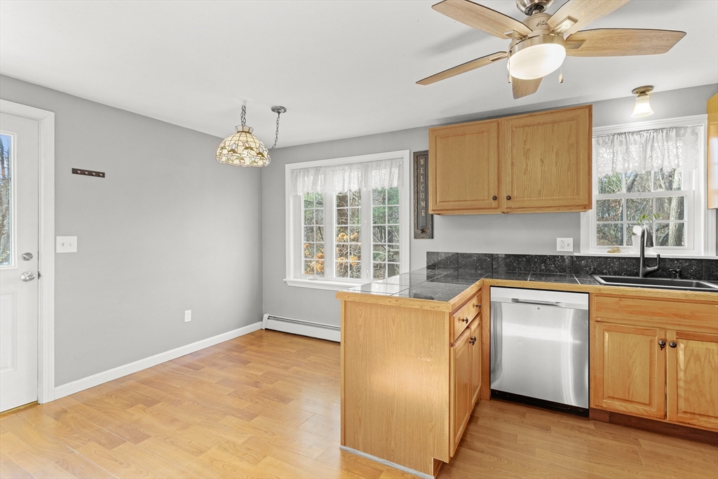 5 A Homestead Drive, Unit A Derry, NH 03038 - Photo 3 of 26 a kitchen with granite countertop a stove a sink dishwasher and a refrigerator