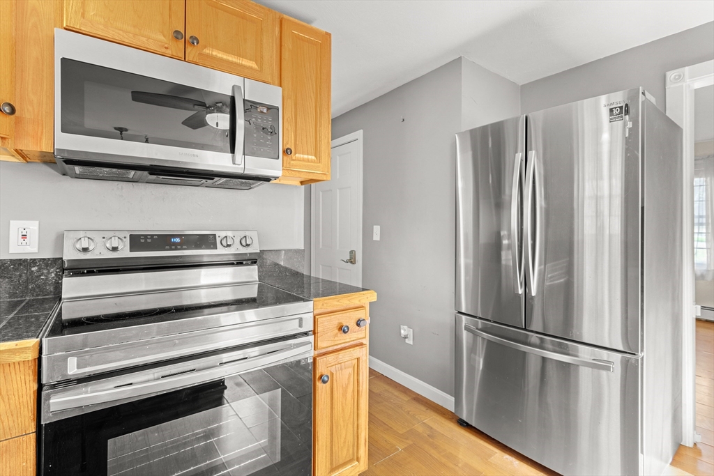 5 A Homestead Drive, Unit A Derry, NH 03038 - Photo 7 of 26 a kitchen with appliances and a refrigerator