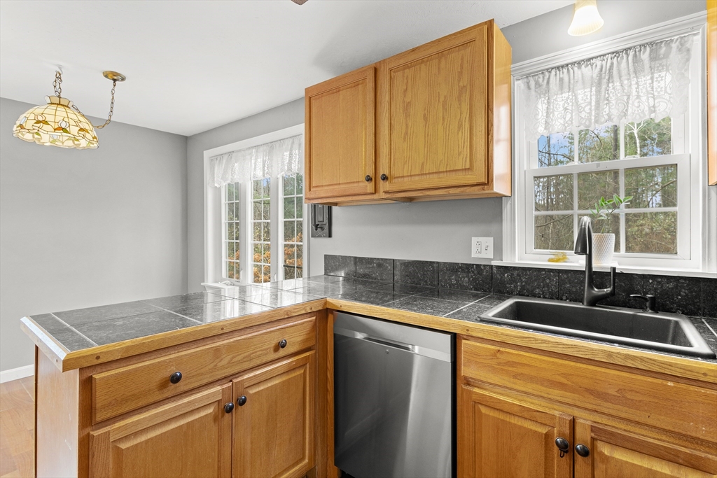 5 A Homestead Drive, Unit A Derry, NH 03038 - Photo 8 of 26 a kitchen with granite countertop cabinets and window