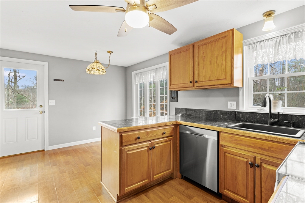 5 A Homestead Drive, Unit A Derry, NH 03038 - Photo 9 of 26 a kitchen with stainless steel appliances granite countertop a sink a stove cabinets and wooden floor