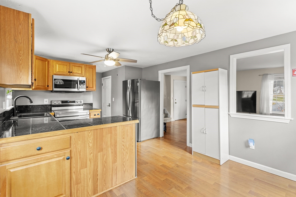 5 A Homestead Drive, Unit A Derry, NH 03038 - Photo 10 of 26 a kitchen with stainless steel appliances granite countertop a refrigerator a stove and a sink