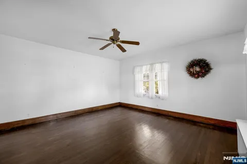 a view of room with hardwood floor and a ceiling fan