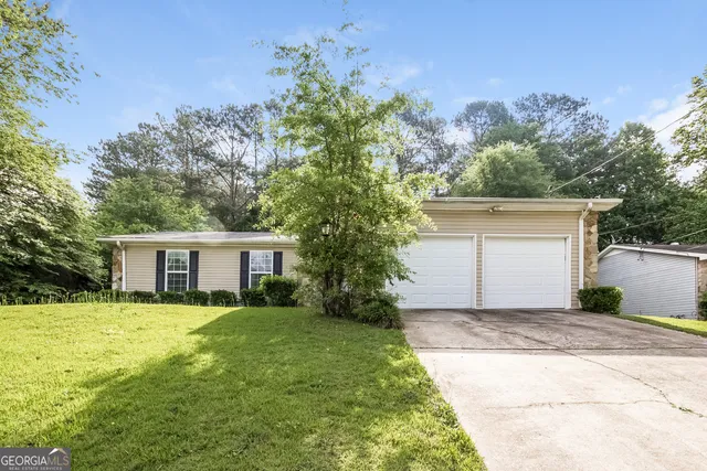 a front view of house with yard and trees around