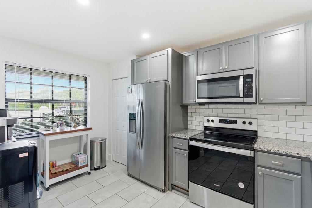 10900 West Sample Road Coral Springs, FL 33065 - Photo 12 of 32 a kitchen with a stove a refrigerator and a sink