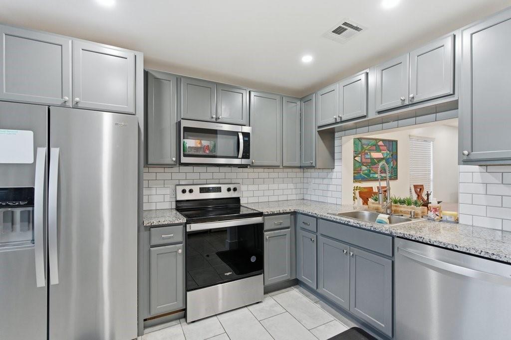 10900 West Sample Road Coral Springs, FL 33065 - Photo 13 of 32 a kitchen with a sink stainless steel appliances and cabinets