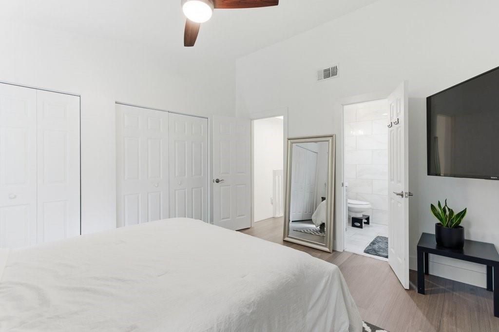 10900 West Sample Road Coral Springs, FL 33065 - Photo 17 of 32 a bedroom with a bed and a potted plant