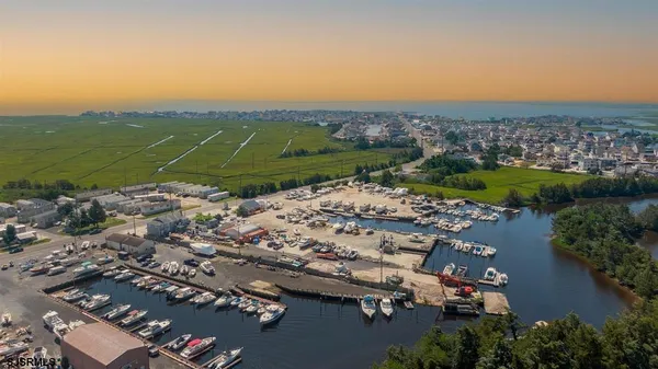 an aerial view of a city with lots of residential buildings ocean and mountain view in back