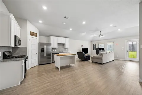 a living room with furniture and kitchen view