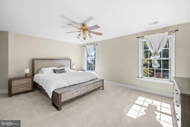 a kitchen with stainless steel appliances kitchen island granite countertop a refrigerator a stove a dining table and chairs with wooden floor