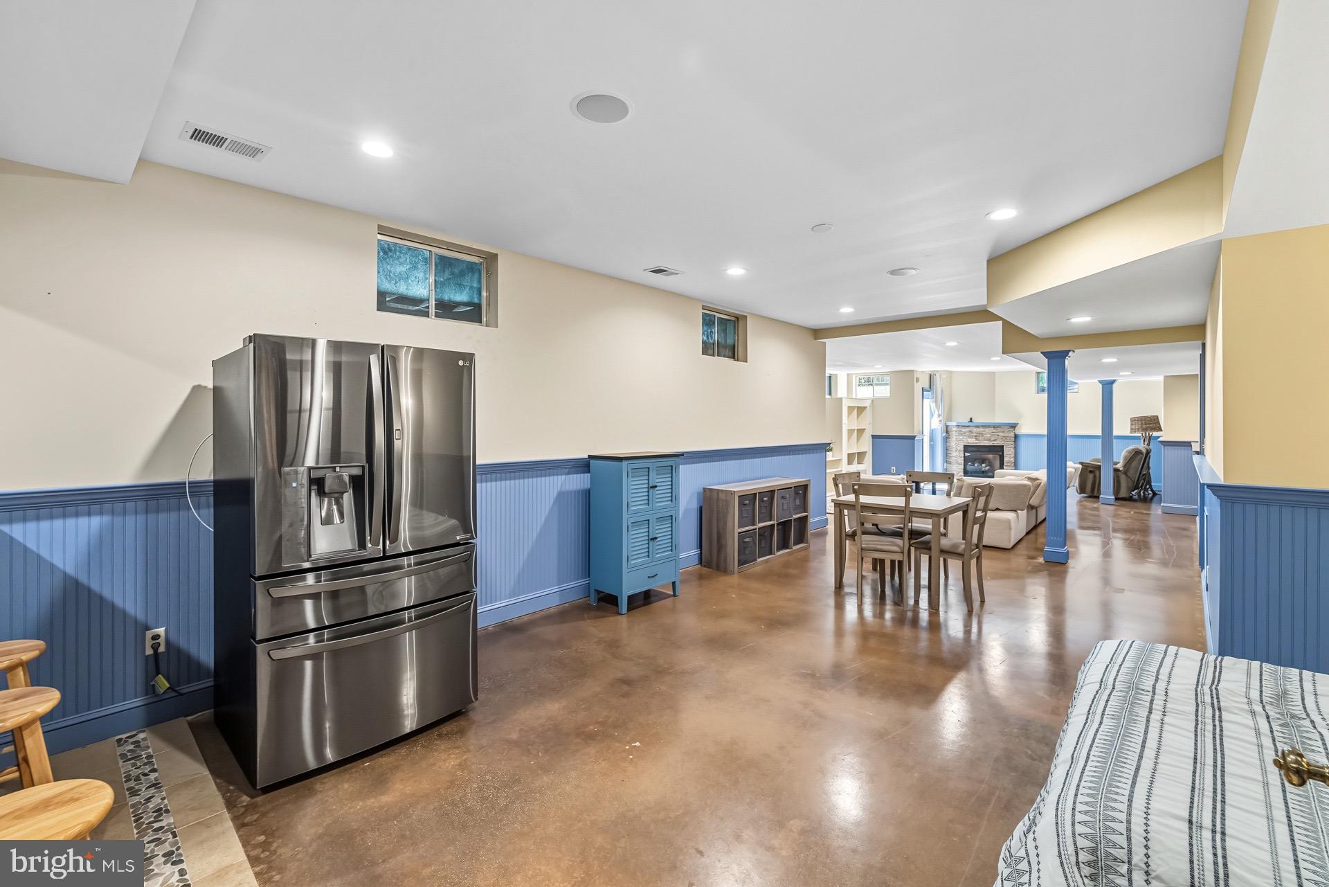 99 Hummingbird Court Dunkirk, MD 20754 - Photo 68 of 82 a kitchen with stainless steel appliances kitchen island granite countertop a refrigerator a stove a dining table and chairs with wooden floor