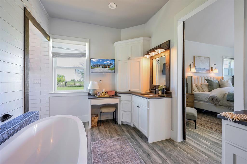 12345 Flow Road Krum, TX 76249 - Photo 20 of 38 Full bathroom featuring ensuite bathroom, a soaking tub, wood finished floors, and plenty of natural light