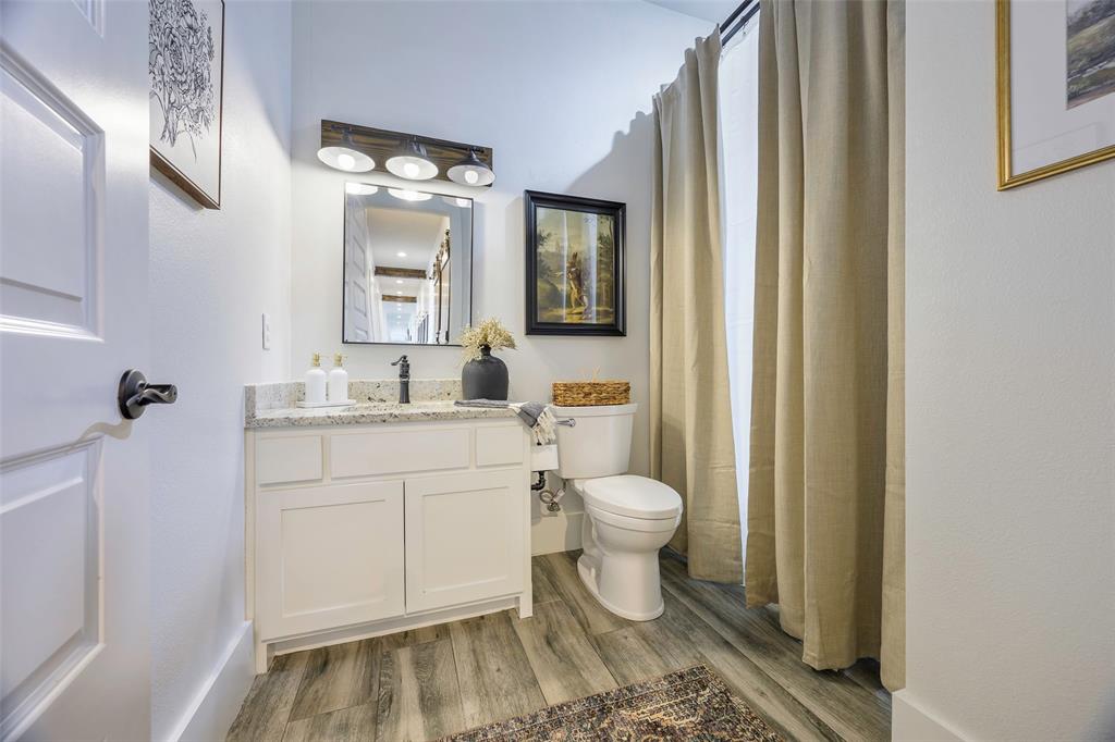 12345 Flow Road Krum, TX 76249 - Photo 24 of 38 Bathroom featuring toilet, vanity, and wood finished floors