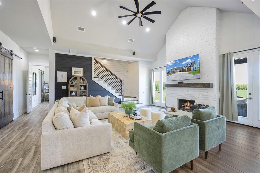 12345 Flow Road Krum, TX 76249 - Photo 5 of 38 Living room with stairway, a barn door, ceiling fan, high vaulted ceiling, and visible vents