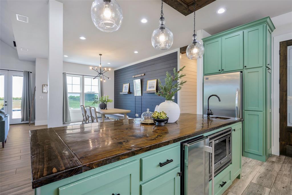 12345 Flow Road Krum, TX 76249 - Photo 10 of 38 Kitchen featuring visible vents, green cabinets, stainless steel appliances, light wood-type flooring, and wine cooler