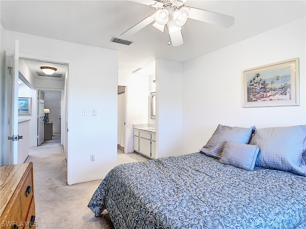 1645 Sand Castle Road Sanibel, FL 33957 - Photo 23 of 34 a bedroom with a bed and a chandelier