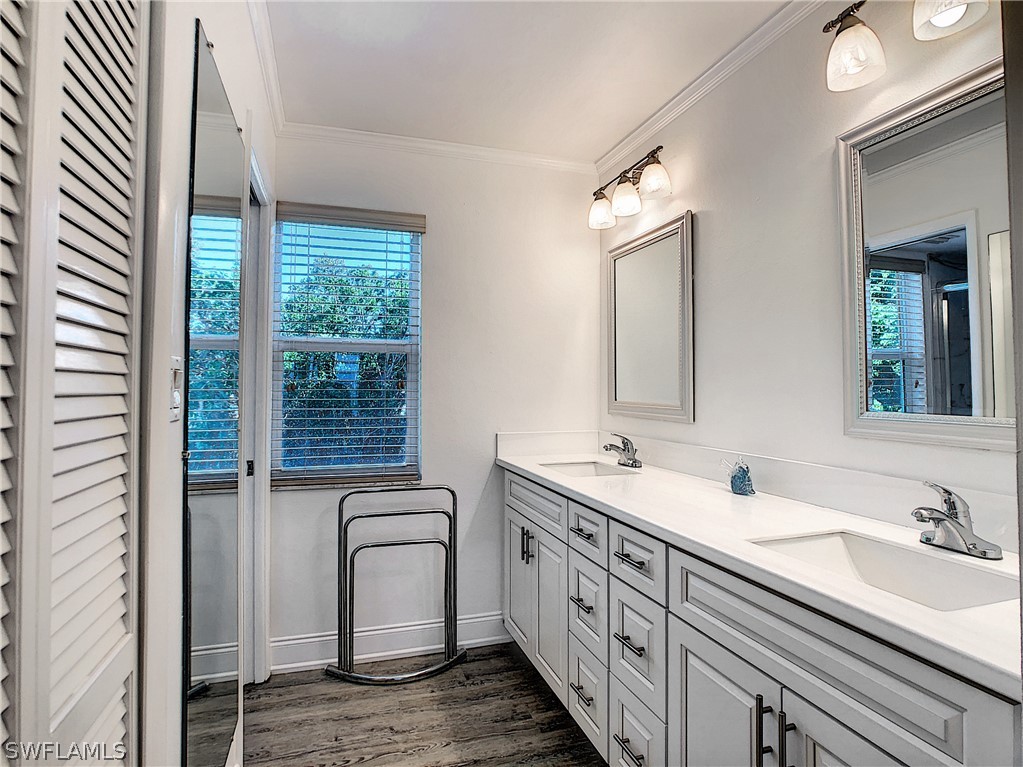 1645 Sand Castle Road Sanibel, FL 33957 - Photo 7 of 34 a bathroom with a double vanity sink and a mirror