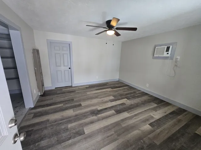 a view of a room with wooden floor and white walls
