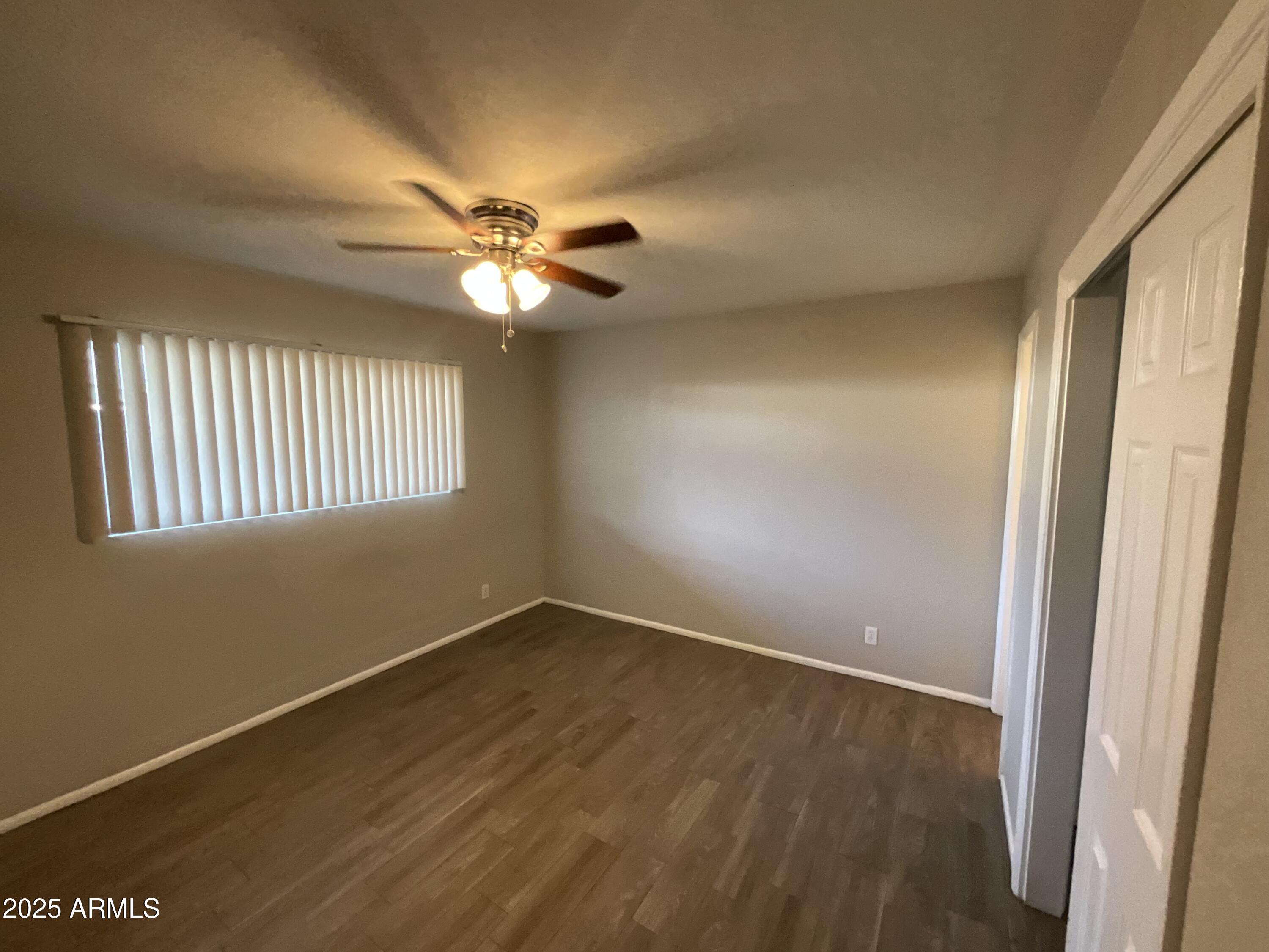 810 East Colter Street, Unit 11 Phoenix, AZ 85014 - Photo 8 of 17 wooden floor in an empty room with a window