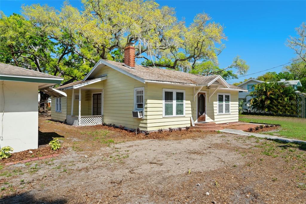 300 President Street Dunedin, FL 34698 - Photo 14 of 53 a view of a white house with a large tree front of house
