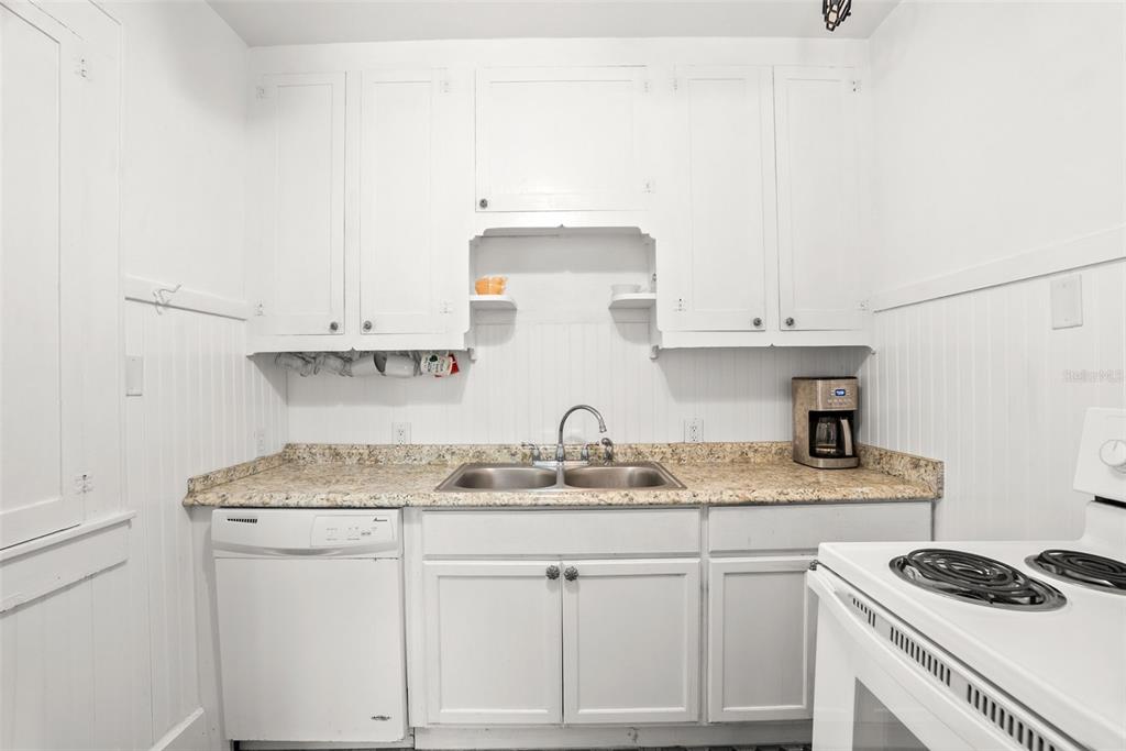 300 President Street Dunedin, FL 34698 - Photo 34 of 53 a kitchen with stainless steel appliances granite countertop a sink stove and cabinets