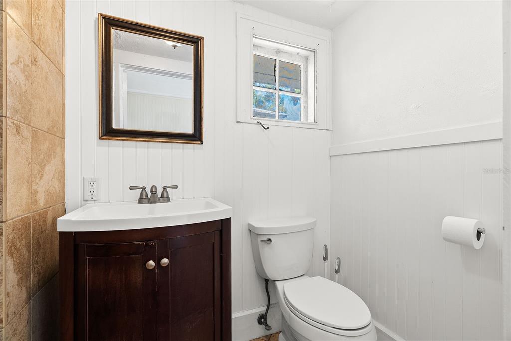 300 President Street Dunedin, FL 34698 - Photo 38 of 53 a bathroom with a toilet a sink and mirror