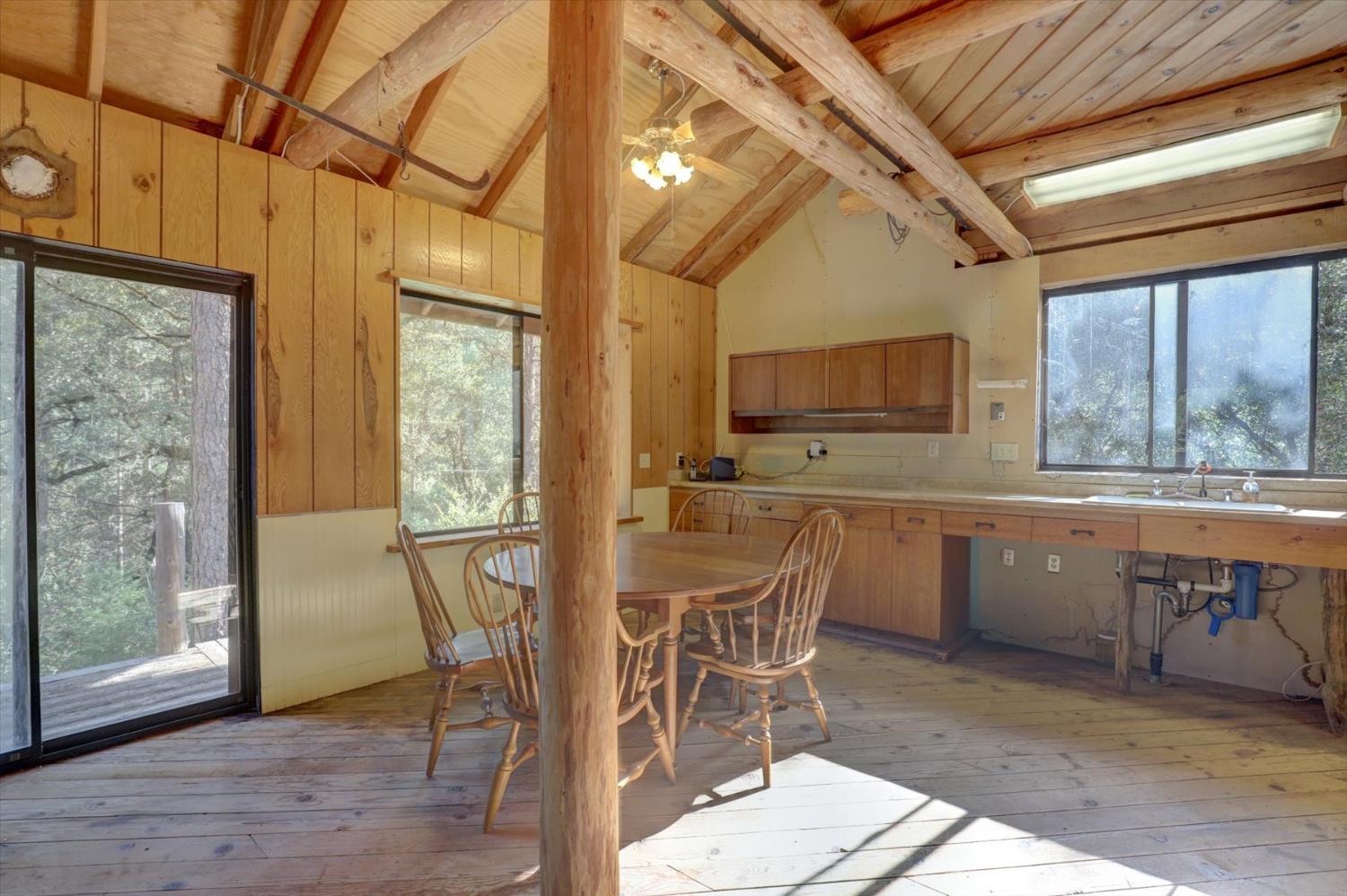 19455 Hogback Road Nevada City, CA 95959 - Photo 30 of 87 a dining room with wooden floor a chandelier a wooden table and chairs