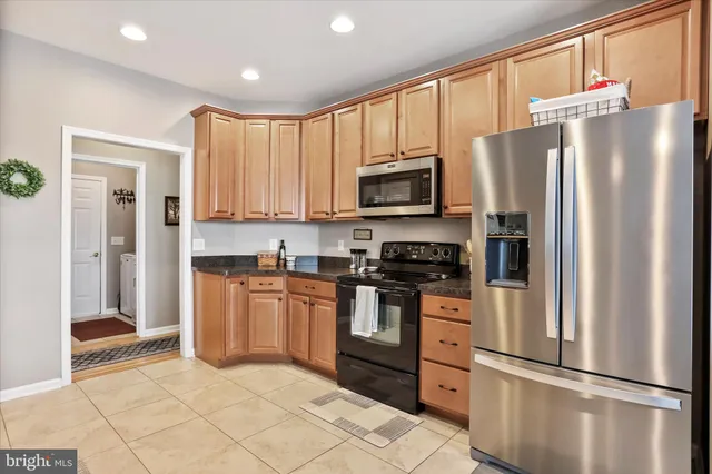 a kitchen with stainless steel appliances granite countertop a refrigerator stove a sink and a microwave