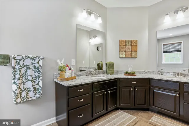 a spacious bathroom with a granite countertop sink and a mirror