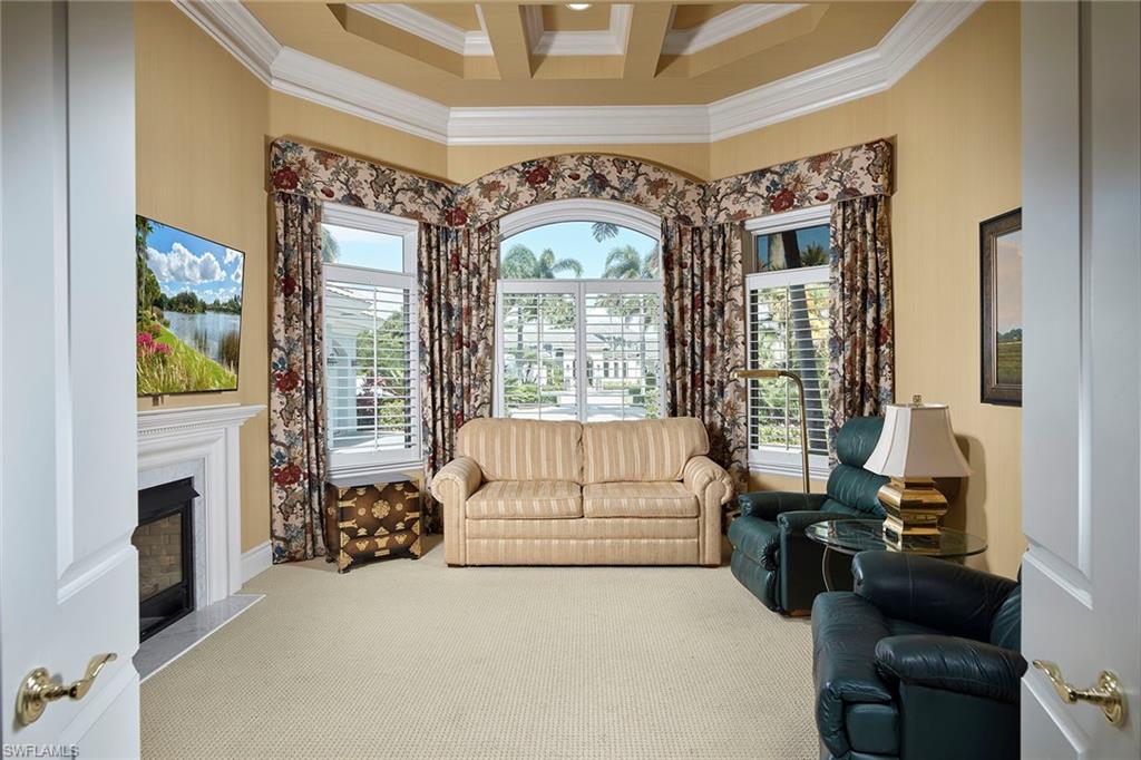 1626 Chinaberry Way Naples, FL 34105 - Photo 12 of 35 a living room with furniture a fireplace and a large window
