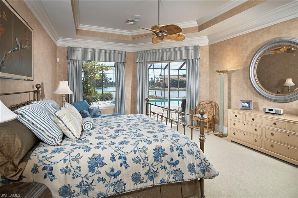 1626 Chinaberry Way Naples, FL 34105 - Photo 13 of 35 a bedroom with a bed a dresser and large window