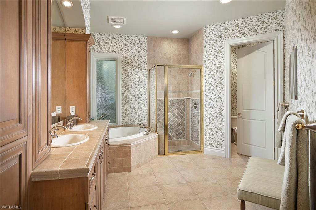 1626 Chinaberry Way Naples, FL 34105 - Photo 16 of 35 a bathroom with a tub sink and mirror