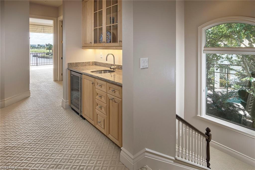 1626 Chinaberry Way Naples, FL 34105 - Photo 19 of 35 a kitchen with granite countertop a sink and a stove next to a window