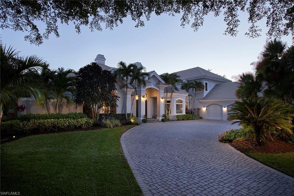 1626 Chinaberry Way Naples, FL 34105 - Photo 2 of 35 a front view of a house with a garden and trees