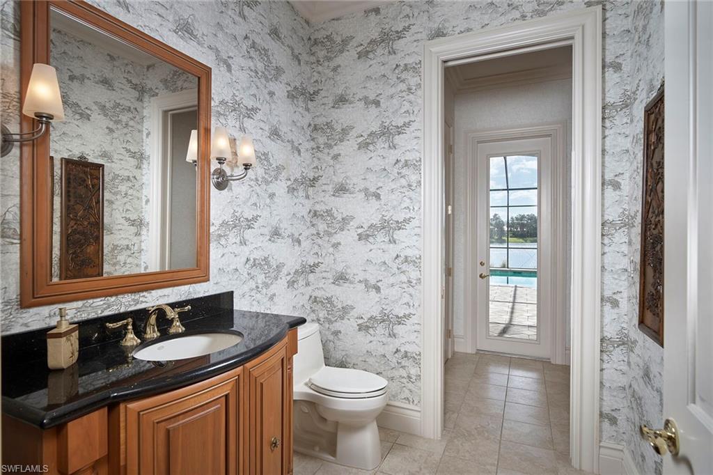 1626 Chinaberry Way Naples, FL 34105 - Photo 26 of 35 a bathroom with a granite countertop sink toilet and mirror