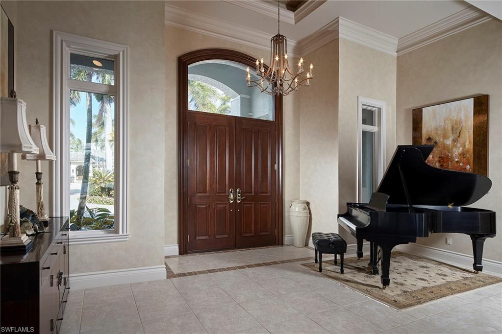 1626 Chinaberry Way Naples, FL 34105 - Photo 6 of 35 a living room with furniture and a chandelier