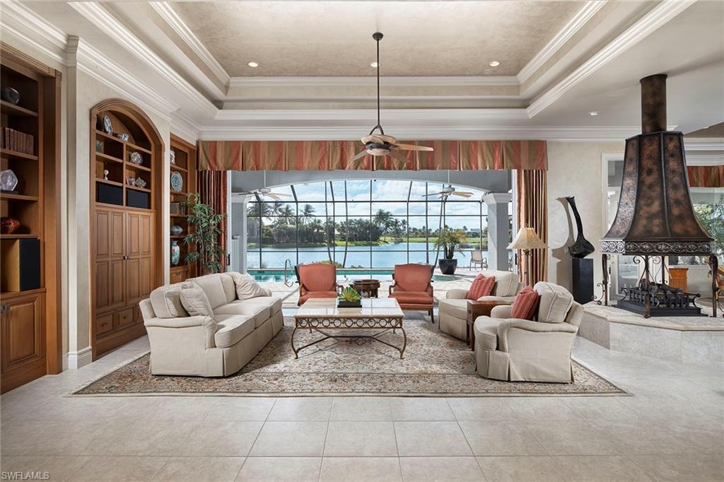 1626 Chinaberry Way Naples, FL 34105 - Photo 7 of 35 a living room with furniture a chandelier and a large window