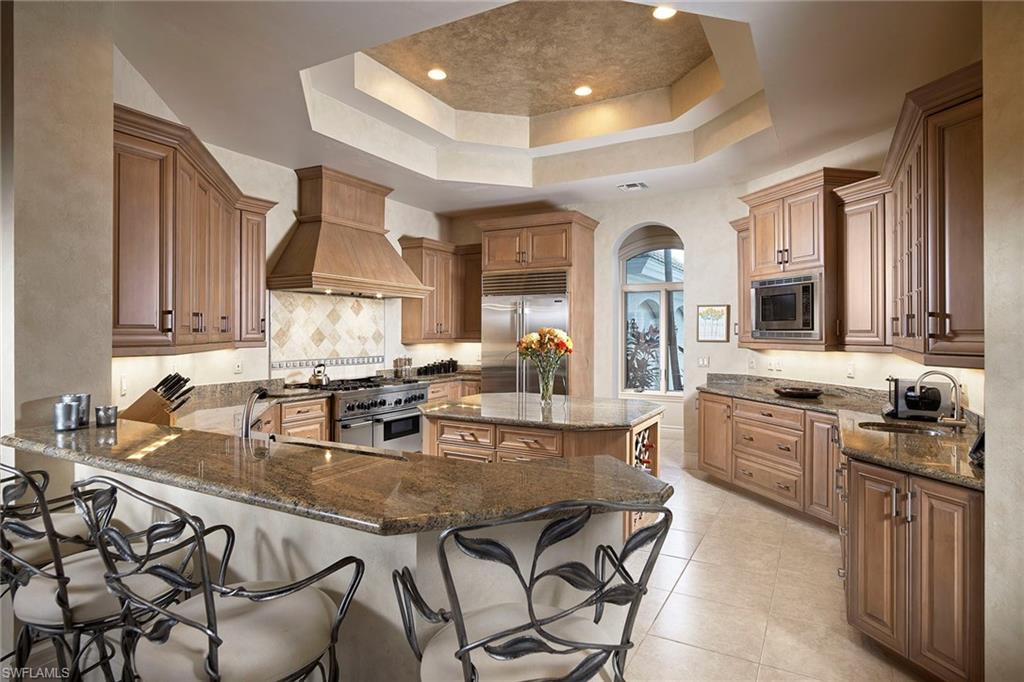 1626 Chinaberry Way Naples, FL 34105 - Photo 8 of 35 a kitchen with kitchen island granite countertop a sink and appliances