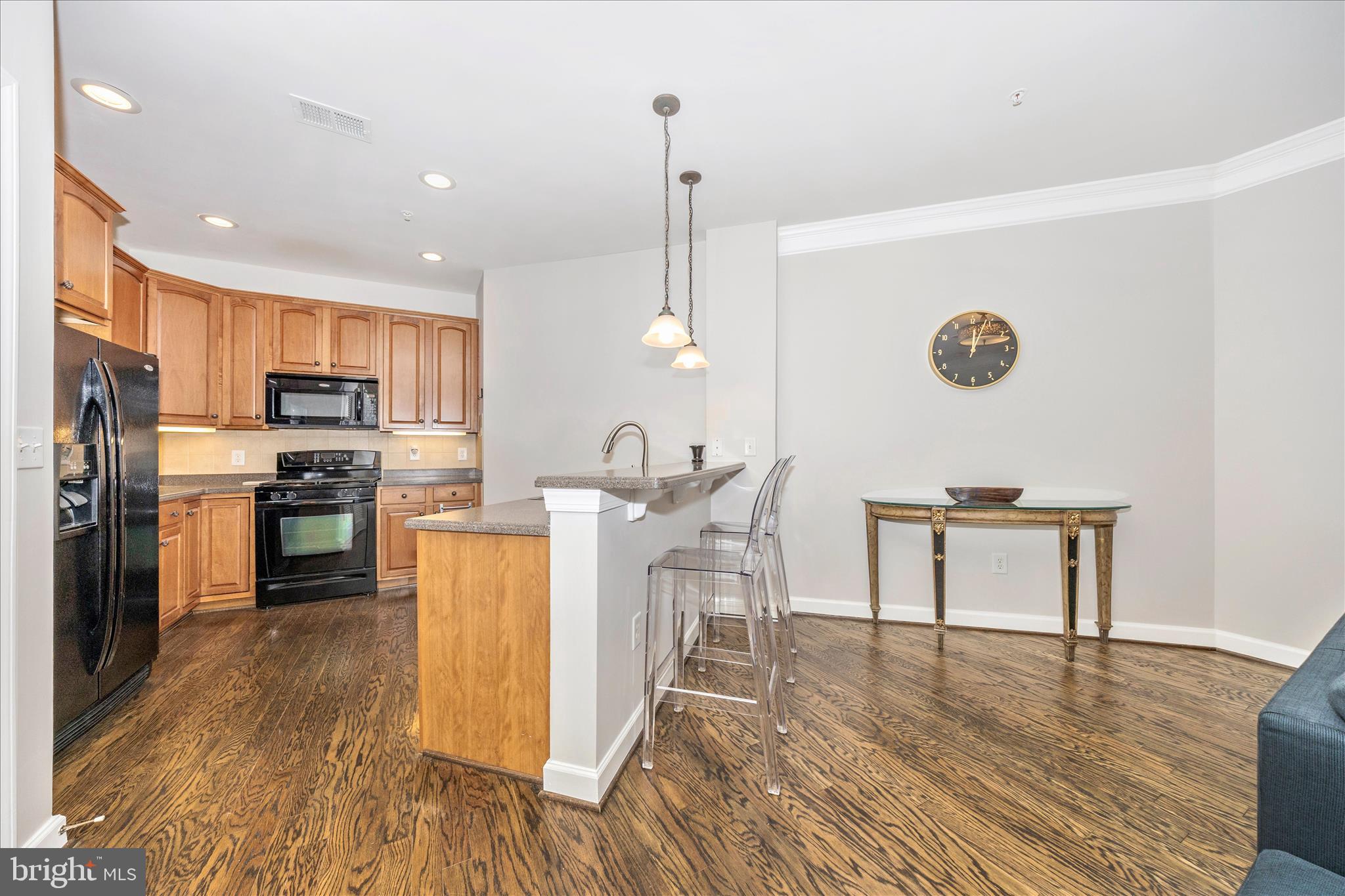 35 East All Saints Street, Unit 114 Frederick, MD 21701 - Photo 11 of 37 a kitchen with stainless steel appliances granite countertop a refrigerator a stove top oven a sink dishwasher a dining table and chairs with wooden floor
