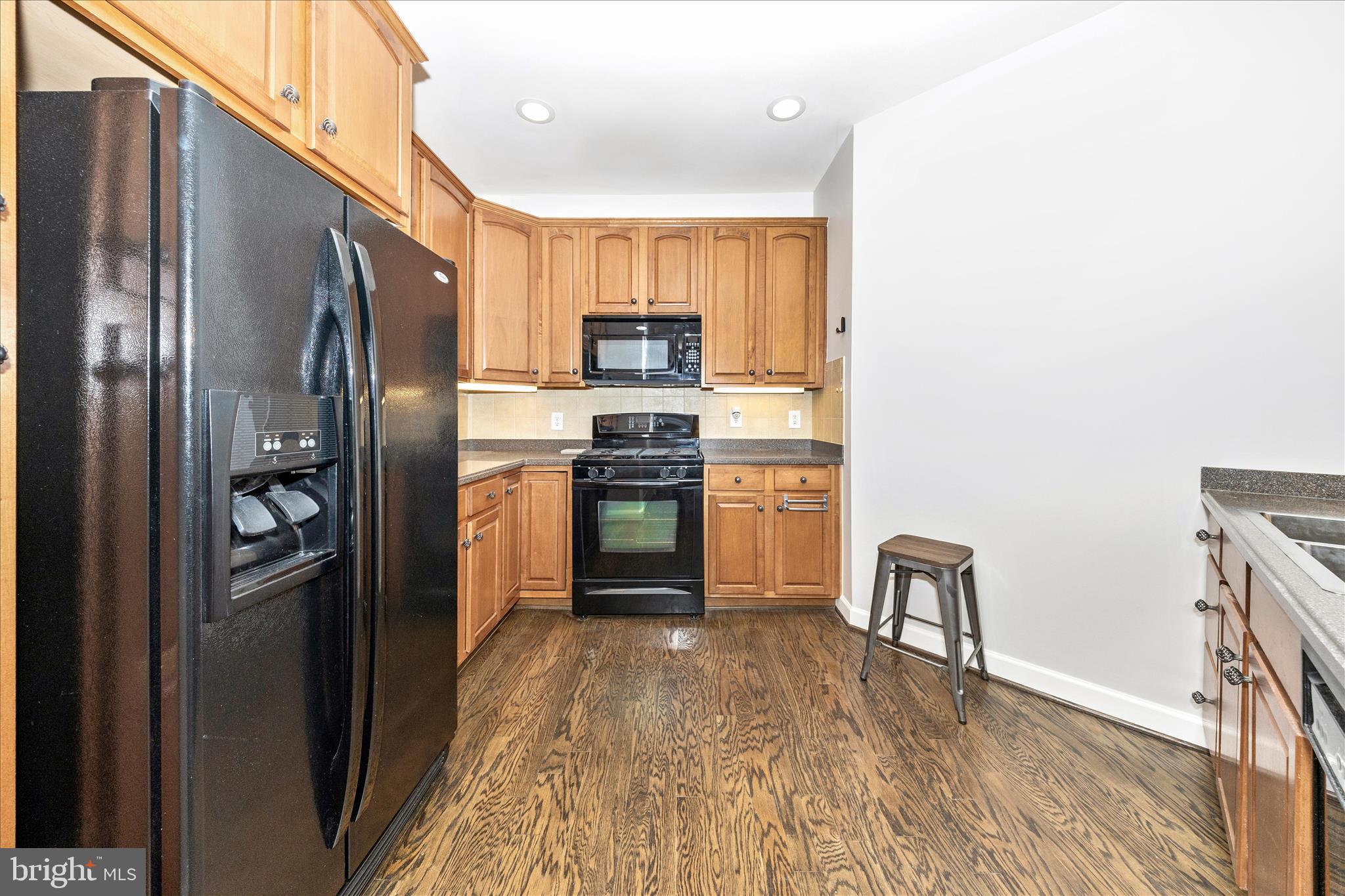 35 East All Saints Street, Unit 114 Frederick, MD 21701 - Photo 15 of 37 a kitchen with stainless steel appliances granite countertop a refrigerator a stove top oven a sink and dishwasher
