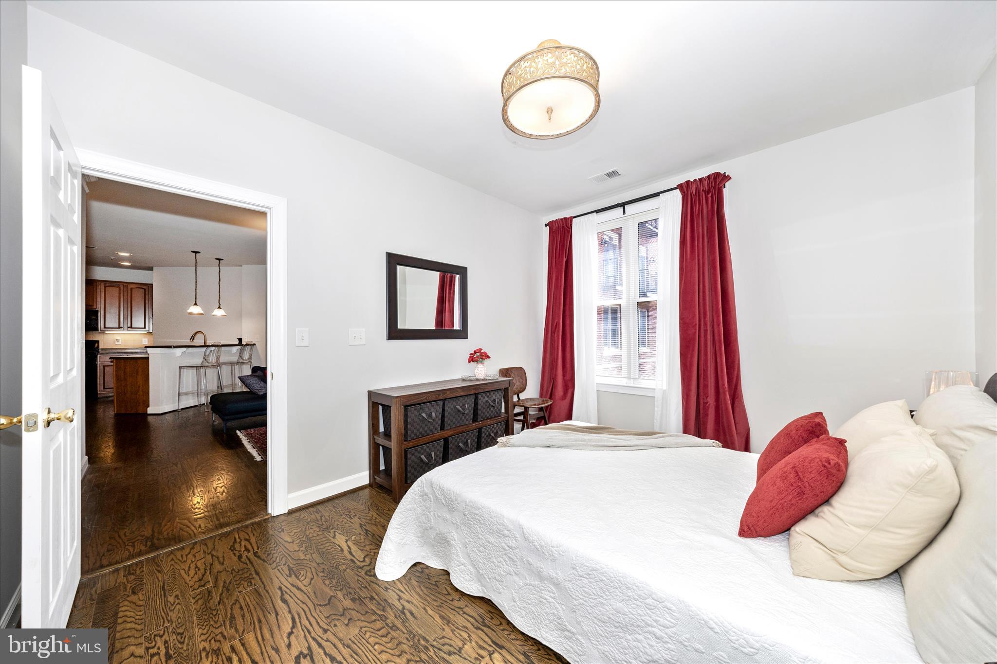 35 East All Saints Street, Unit 114 Frederick, MD 21701 - Photo 20 of 37 a bedroom with a large bed and a chandelier
