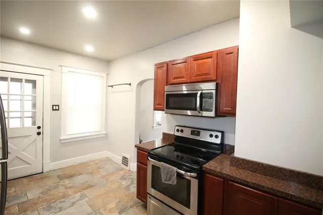 a kitchen with stainless steel appliances granite countertop a stove and a microwave