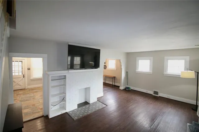 a view of a livingroom with wooden floor and a flat screen tv