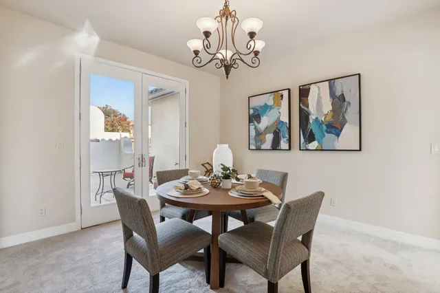 a kitchen with a table chairs stove and white cabinets