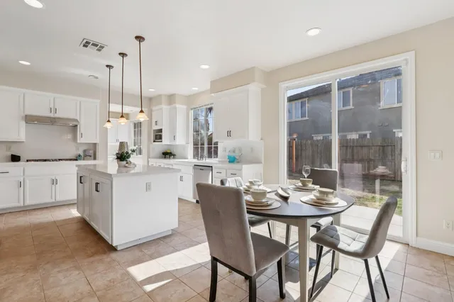 a large kitchen with kitchen island a sink a center island a stove and a window