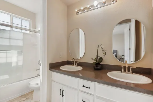 a bathroom with a tub a sink and a window