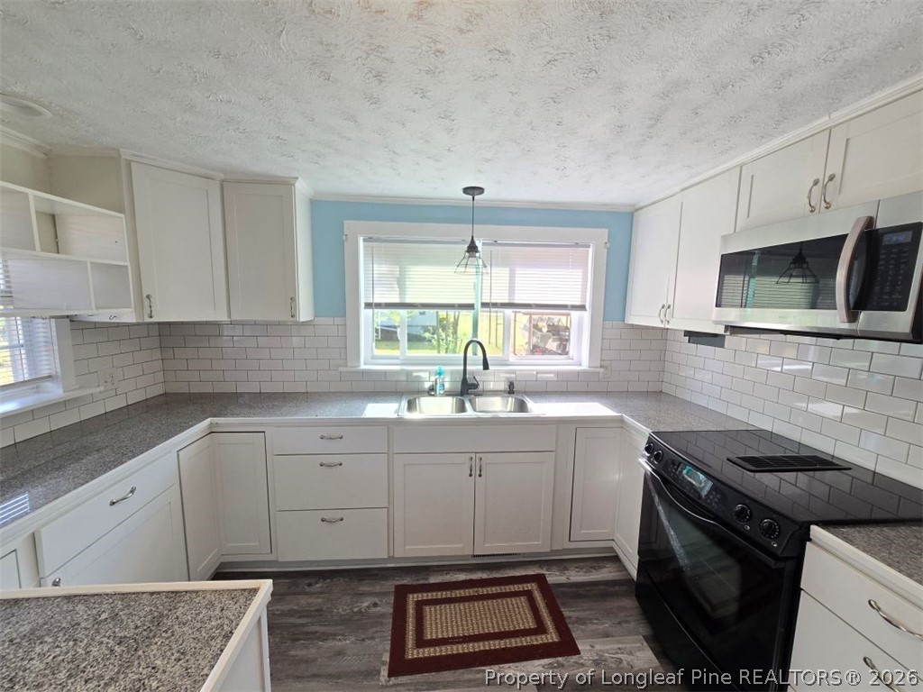 219 East Clinton Street Autryville, NC 28318 - Photo 3 of 32 a kitchen with a sink stove and microwave
