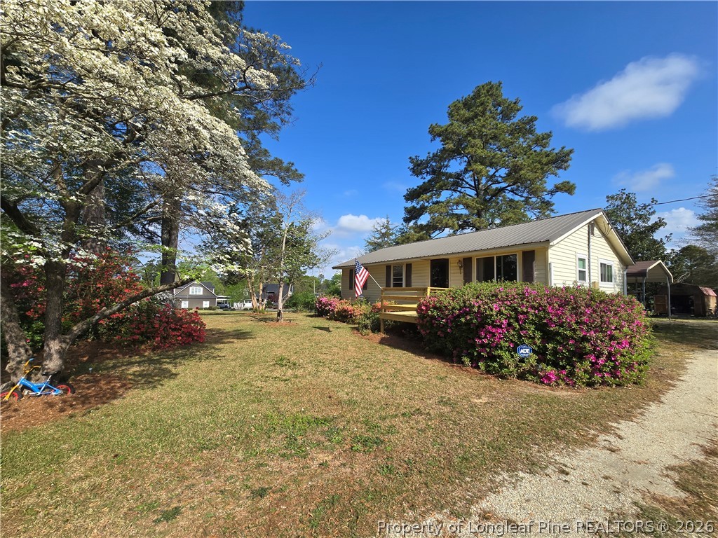 219 East Clinton Street Autryville, NC 28318 - Photo 31 of 32 a front view of a house with a garden and trees