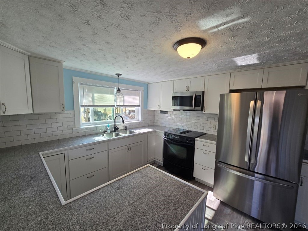 219 East Clinton Street Autryville, NC 28318 - Photo 4 of 32 a kitchen with a sink stainless steel appliances and cabinets