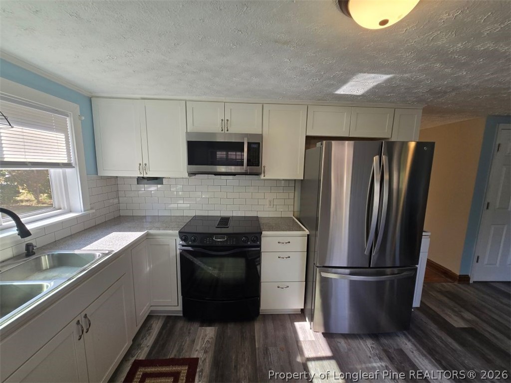 219 East Clinton Street Autryville, NC 28318 - Photo 5 of 32 a kitchen with a refrigerator sink and stove