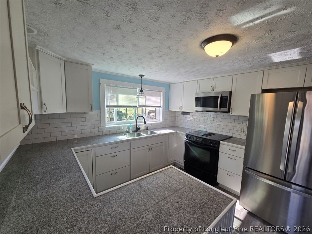 219 East Clinton Street Autryville, NC 28318 - Photo 7 of 32 a kitchen with a sink stainless steel appliances and cabinets